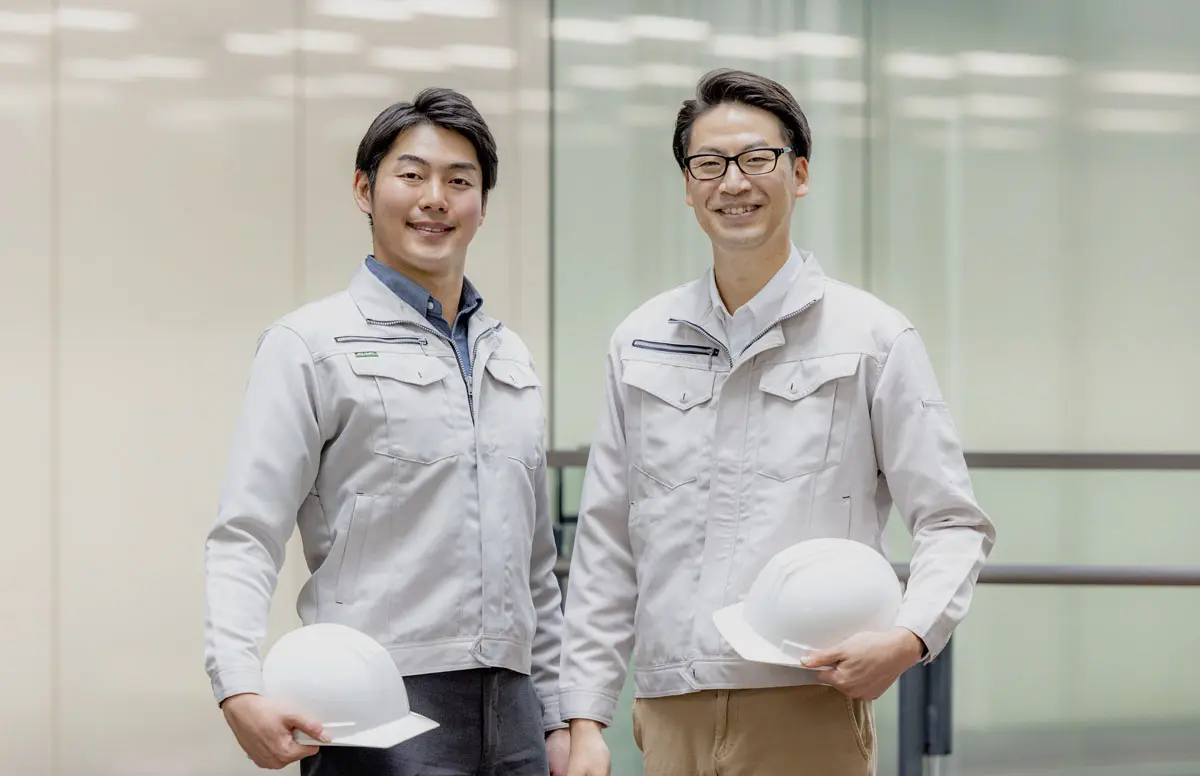 ヘルメットを持つ二人の施工スタッフ